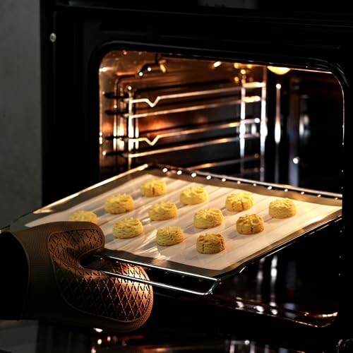 Tray of cookies being placed in an oven.