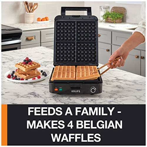 Waffle maker on kitchen counter with waffles and berries