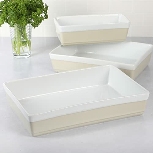 Three ceramic baking dishes on a countertop with parsley in the background.