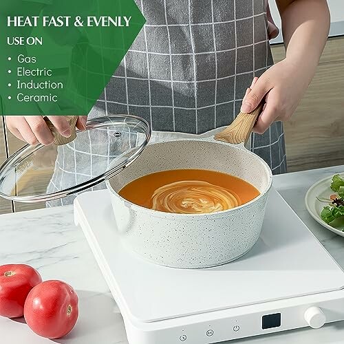 Person cooking soup on induction stove with pot and lid.