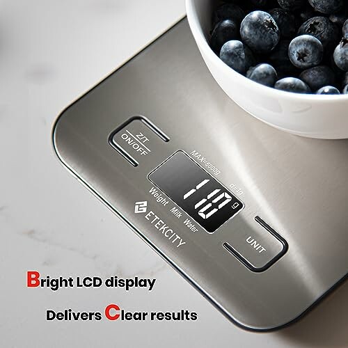 Digital kitchen scale with bowl of blueberries on top.