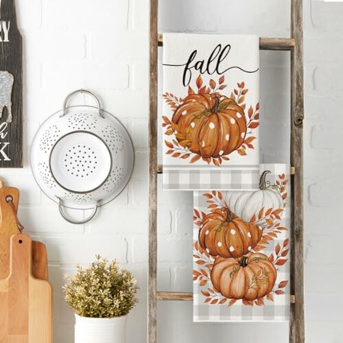 Fall-themed kitchen decor with pumpkin towels on a wooden ladder.