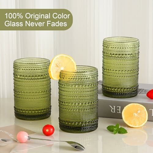 Three green textured glasses with lemons and cherry tomatoes.