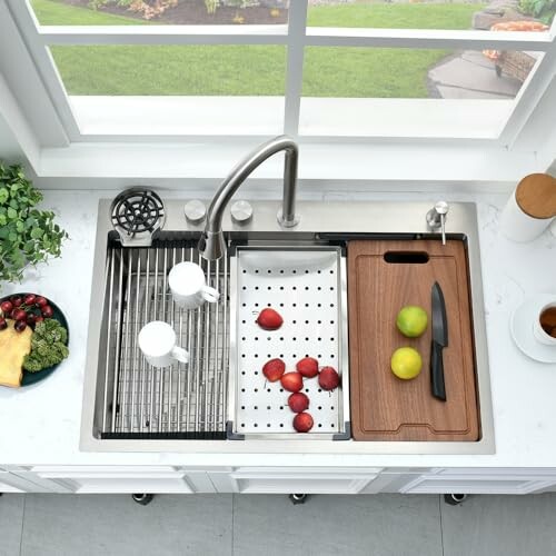 Overhead view of a kitchen sink with accessories, including a cutting board, knife, and fruits.