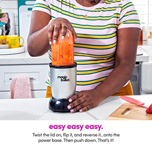 Person blending fruit in a Magic Bullet blender in a kitchen