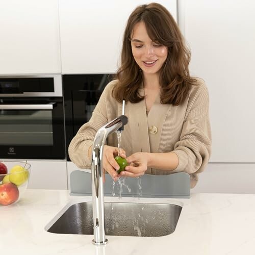 Woman washing an apple at a kitchen sink